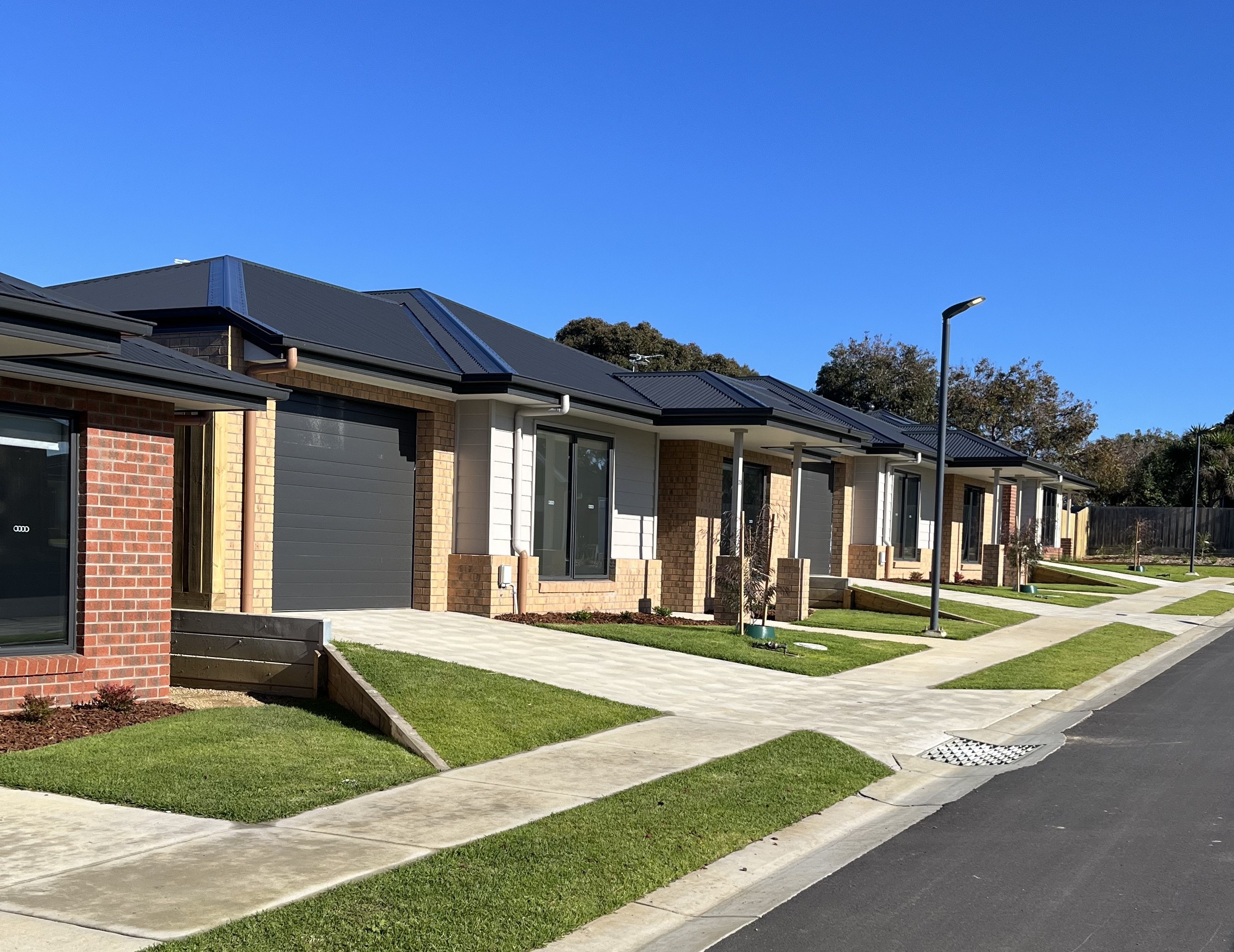 Portland social housing — brick homes with dark metal roofing